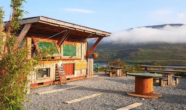 converted shed and outdoor dining space with mountain views in the background