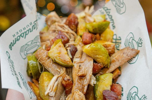 fries with turkey, brussel sprouts and gravy in a takeaway basket