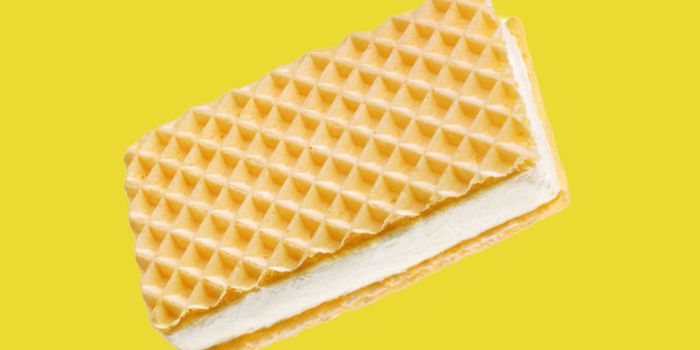 vanilla ice cream in between two wafers on a yellow background
