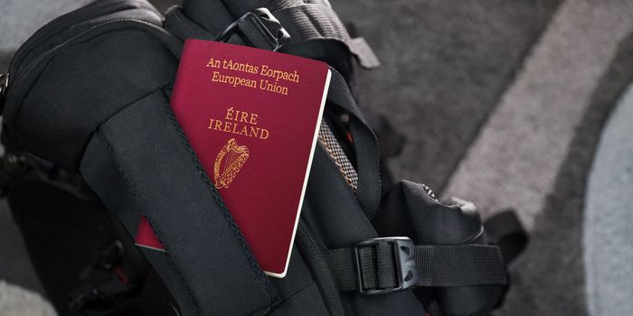 irish passport tucked into the top of a black bagpack