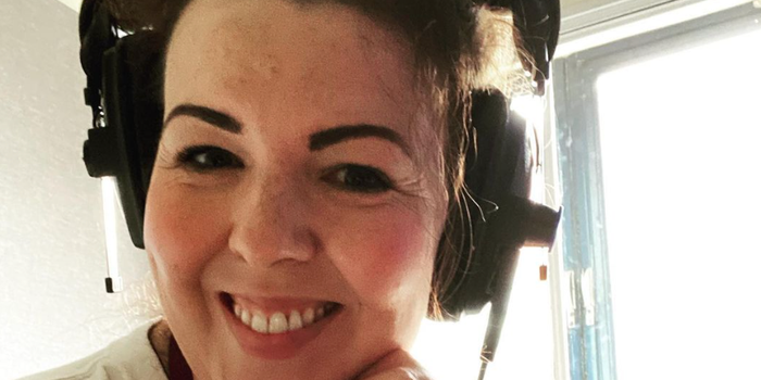 close up of Lisa McGee smiling and wearing radio headphones