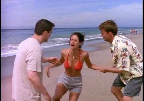 Joey, Monica and Chandler from Friends on a beach - Monica is crying in pain after being stung by a jellyfish