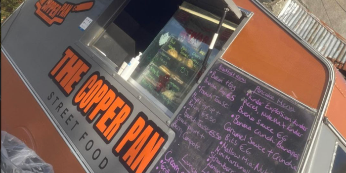 exterior of copper pan street food truck, painted orange and grey with menu written in chalk