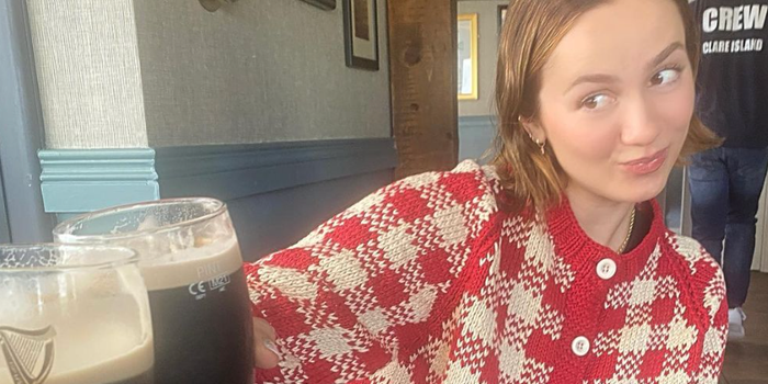 Maude Apatow sharing a 'cheers' over two pints of guinness with another person who is out of shot