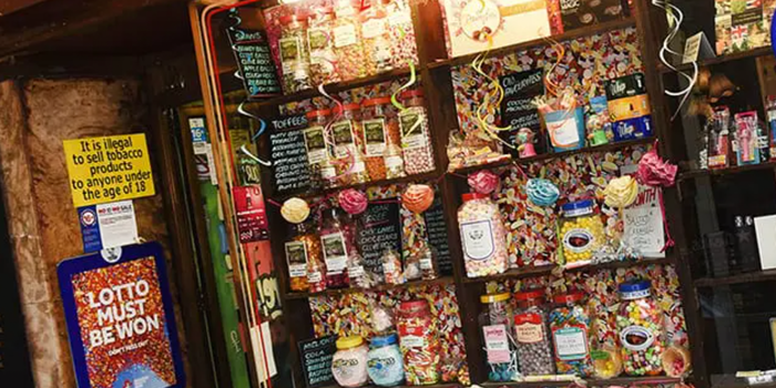 old fashioned sweet shop with several jars of sweets lined up on shelves behind the counter