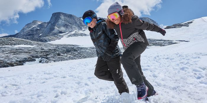two kids on a ski slope in full ski gear