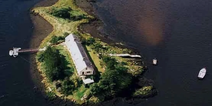 aerial shot of a private island with a long single storey property on it