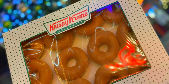 multipack of krispy kreme donuts with christmas lights in the background