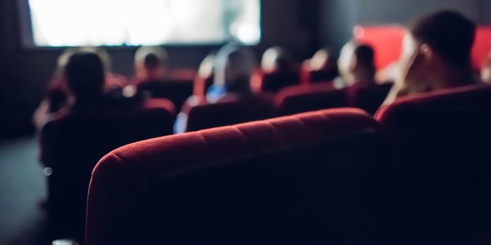 out of focus shot of people inside a cinema watching a film