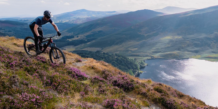 cyclist on a mountain in wicklow with view of a lake and more mountains below