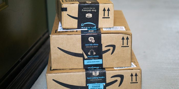 a pile of amazon packages waiting outside a front door