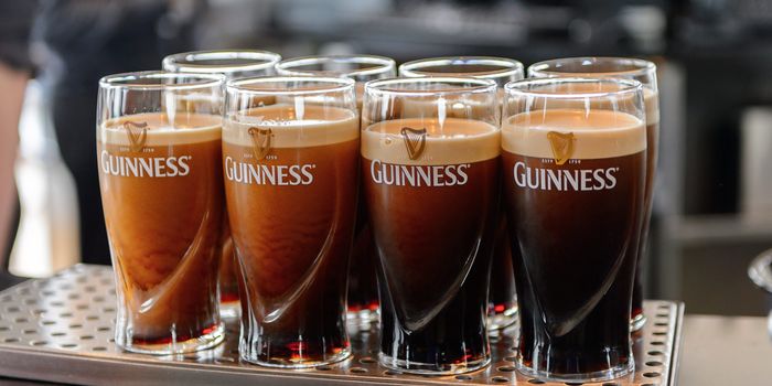 half poured pints of guinness waiting on a bar