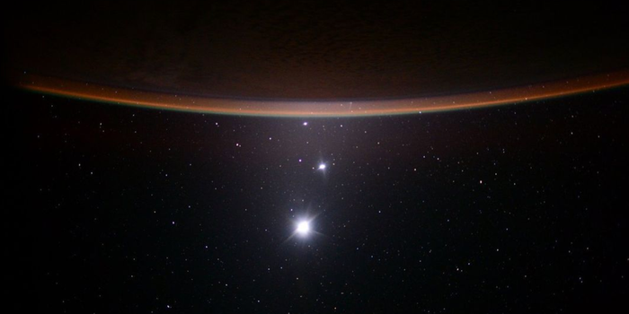 jupiter, venus and a crescent moon as seen from the distance in space